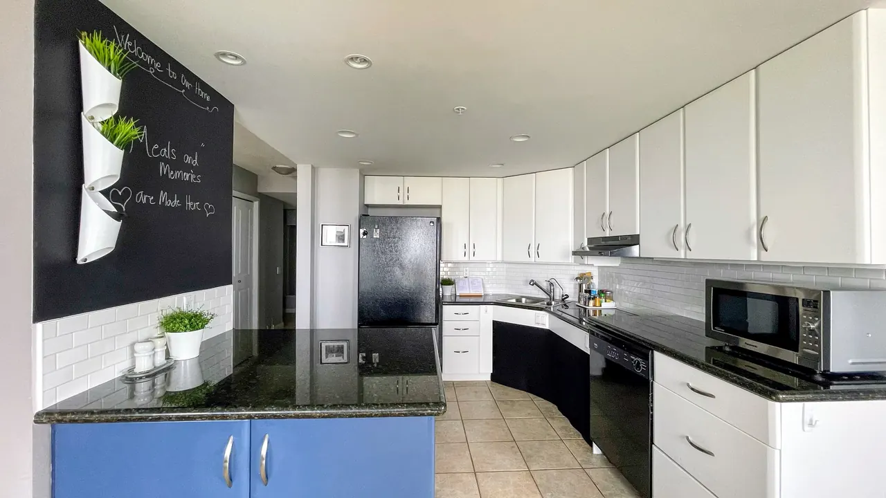 Kitchen with white cabinets, granite counters and a blue island